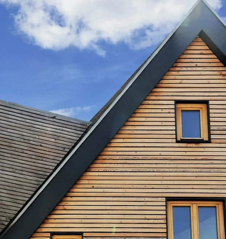 Chantier de construction en bois avec charpente traditionnelle en cours d'assemblage