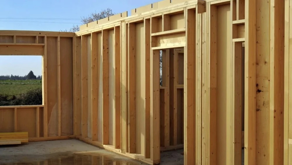 Chantier de construction en bois avec charpente traditionnelle en cours d'assemblage