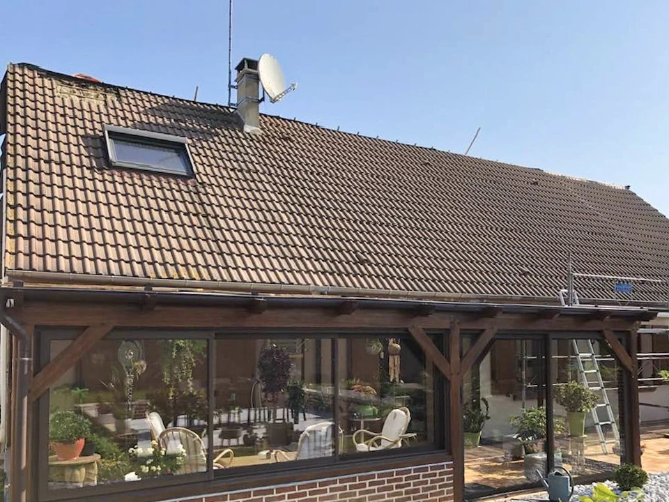 Maison individuelle en rénovation avec toiture en tuiles terre cuite partiellement dégradée