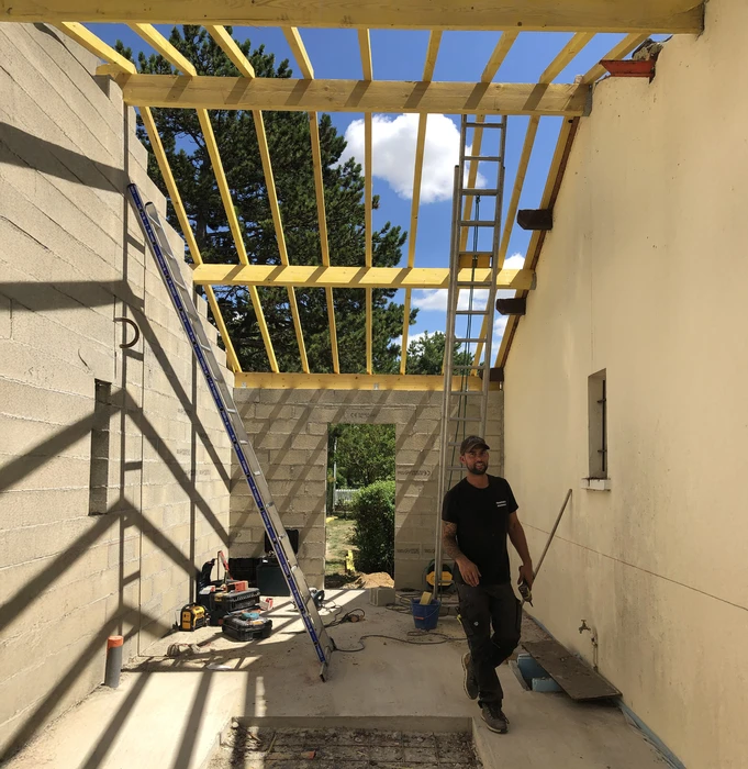 Chantier de construction d'extension résidentielle avec ouvrier en action